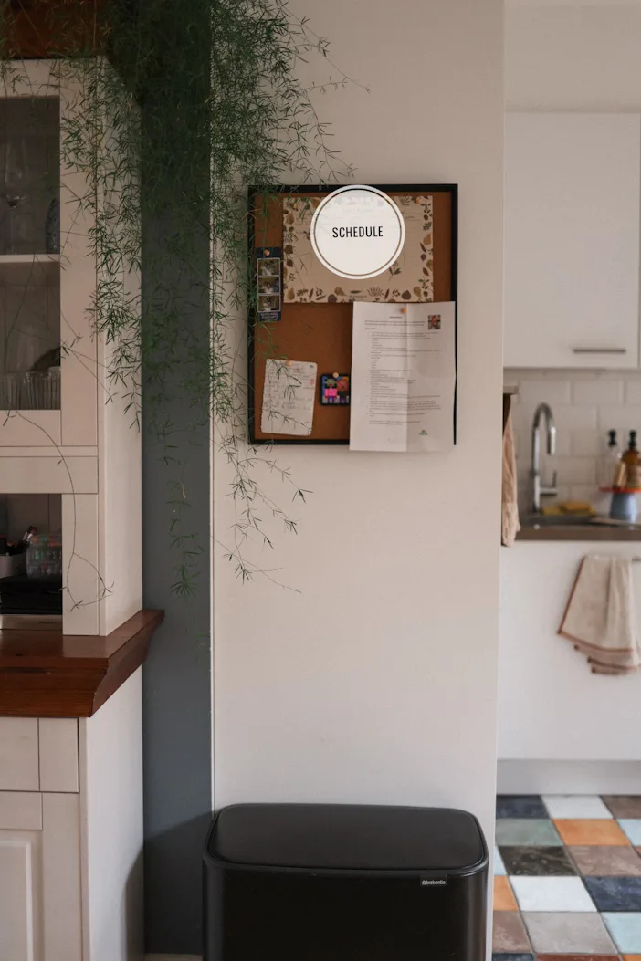 Family memory board with a weekly calendar and task and photo hanging in the kitchen.