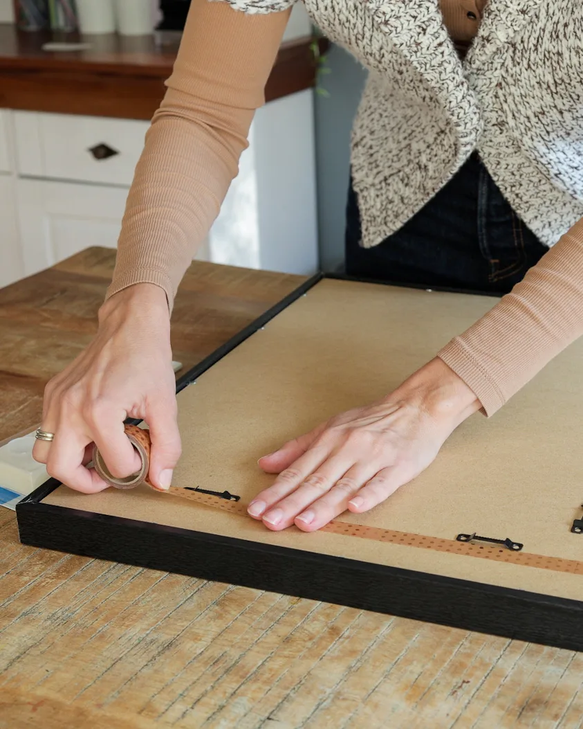 Washi tape applied to the back of a frame to mark where the hooks go.